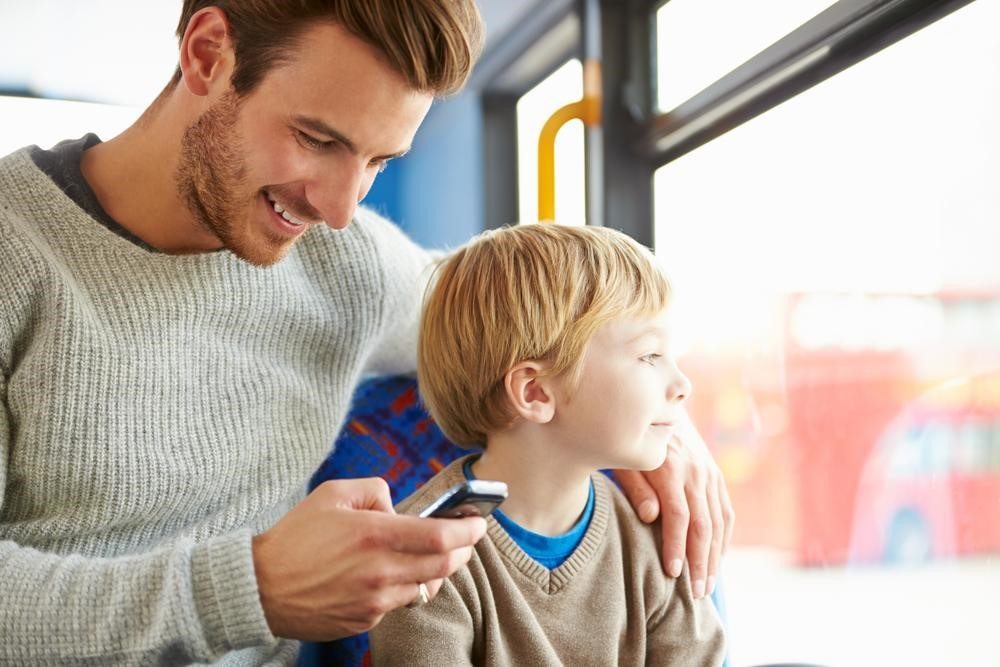 Parent on smartphone next to child